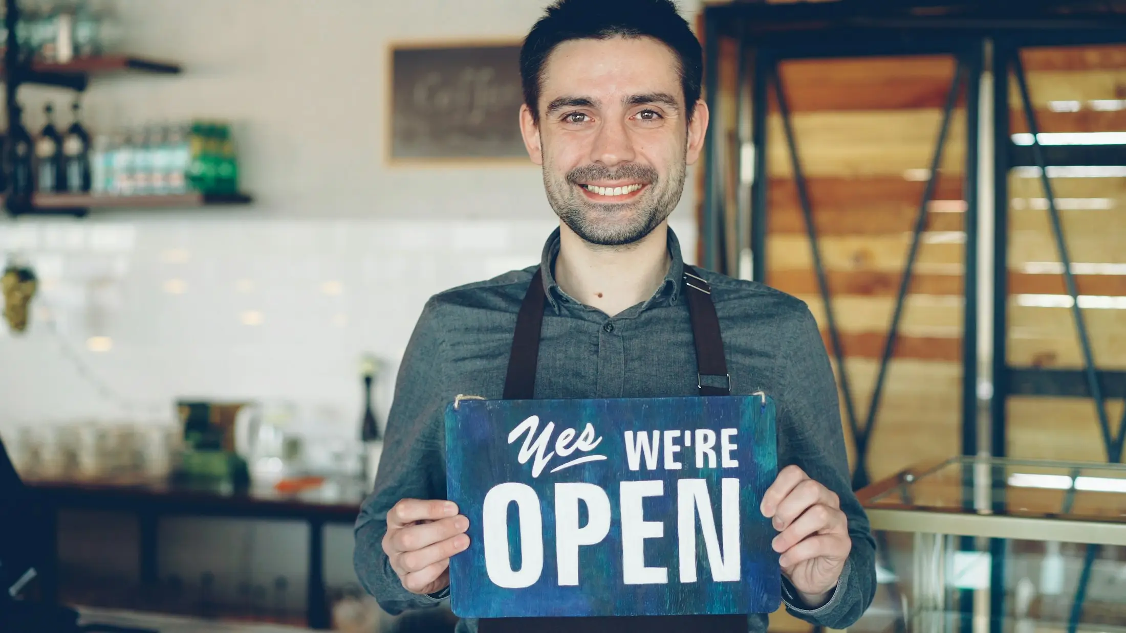 Small business owner holding an open sign