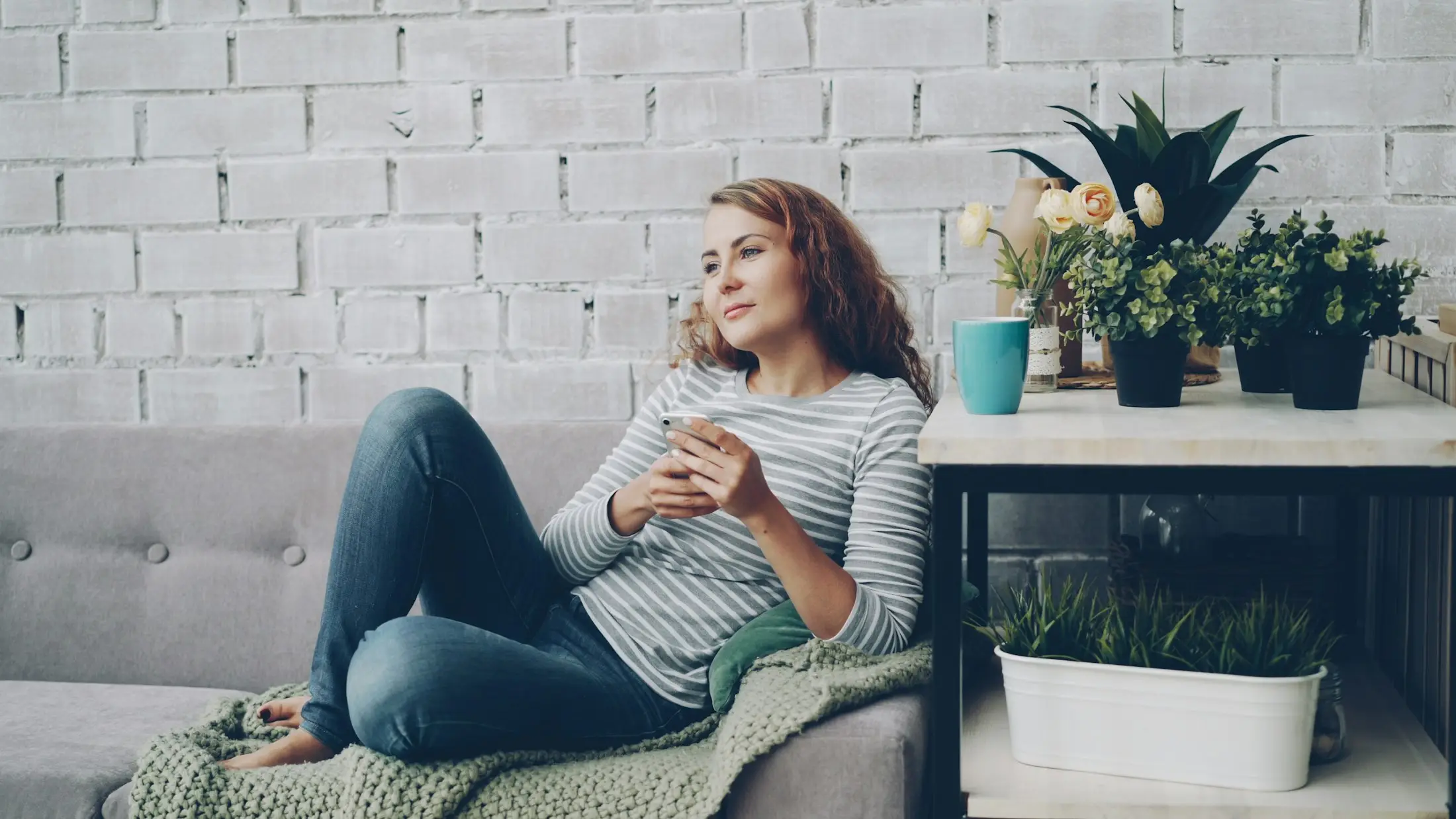 Woman relaxing on the sofa with a hot drink