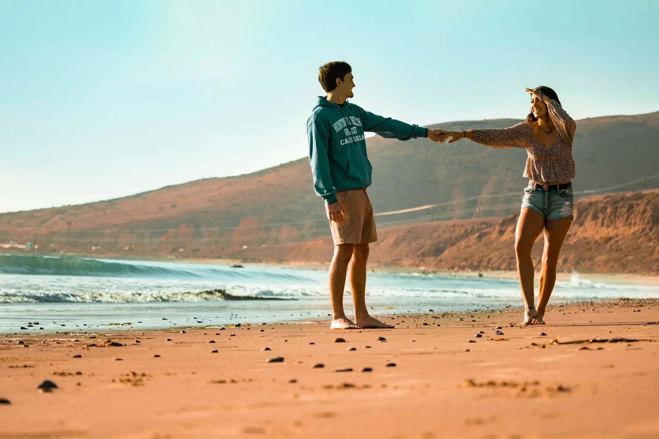 Couple dancing on the beach at golden hour