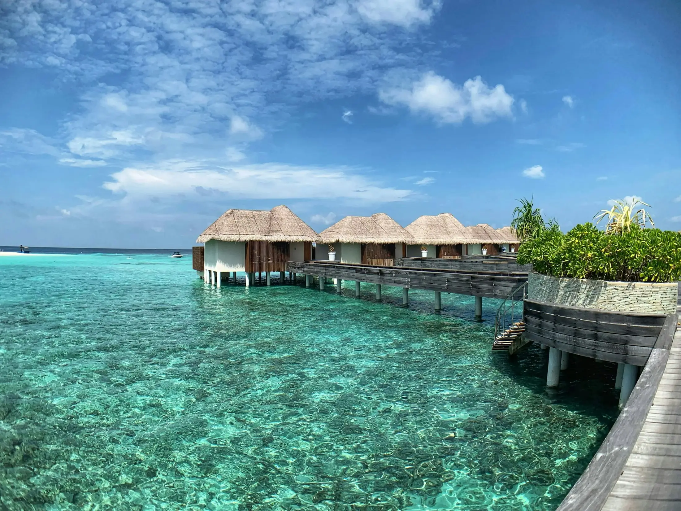 Overwater villas above a clear turquoise lagoon