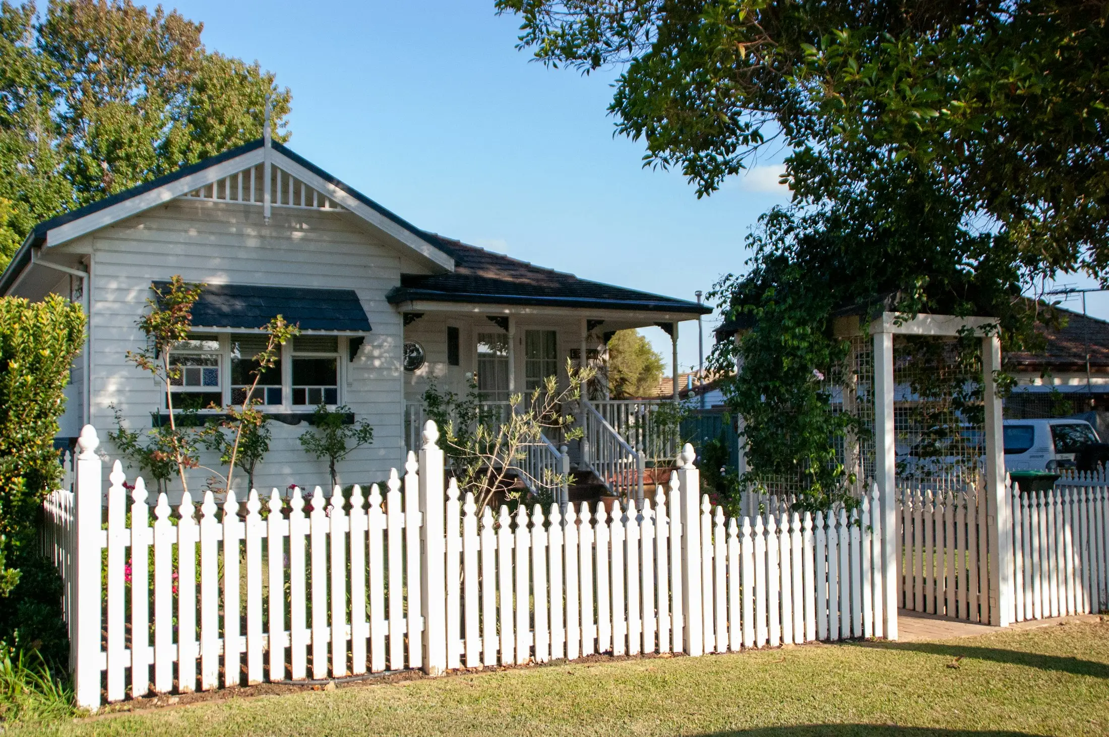 Classic Australian weatherboard home with a white picket fence