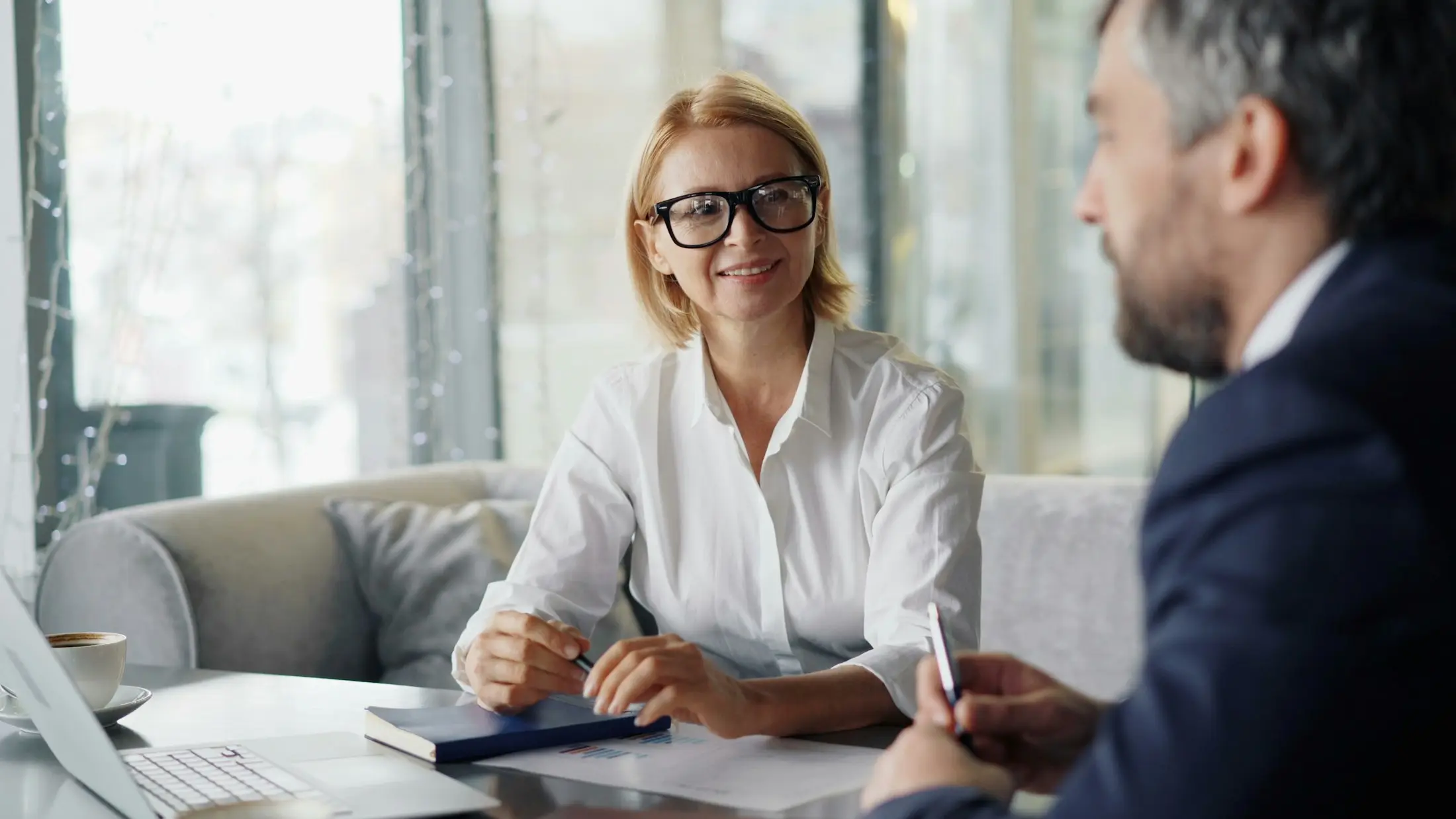 Client talking through legal costs with an adviser at a table with a laptop